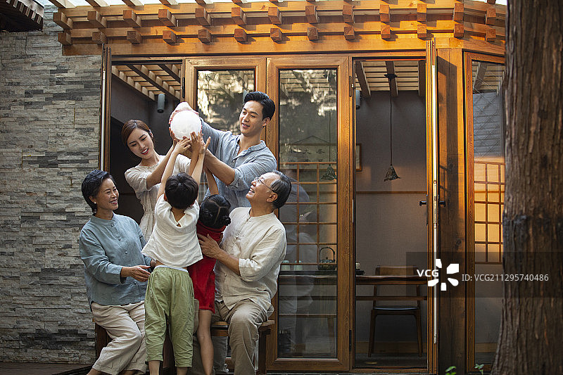 中秋节一家六口户外庭院拿着月球灯嬉戏玩耍图片素材