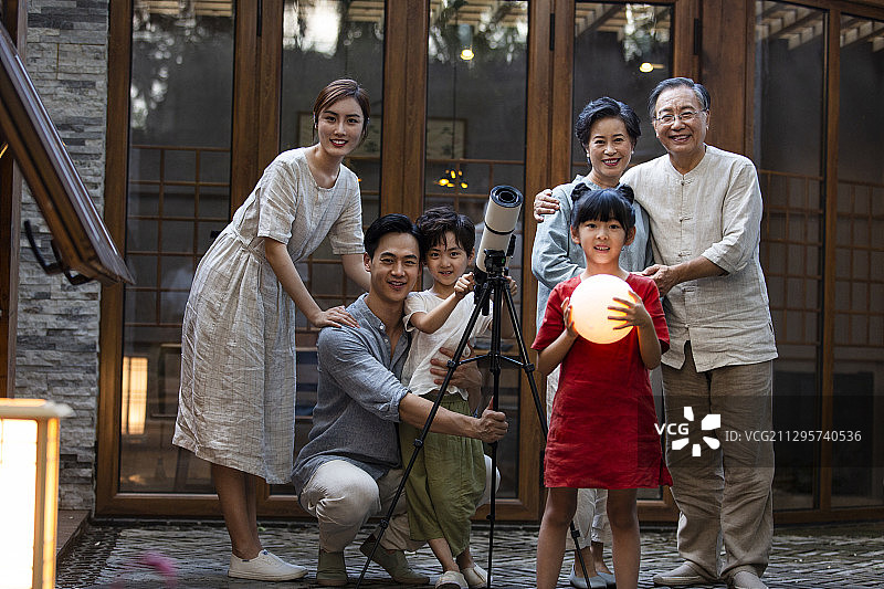 中秋节一家六口在户外庭院用天文望远镜看月亮全家福图片素材