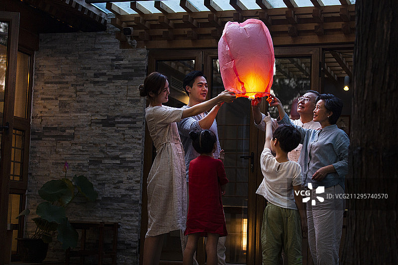 中秋节一家六口户外庭院放孔明灯许愿图片素材