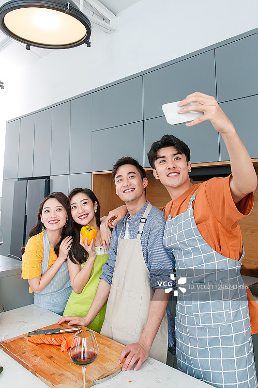 快乐的年轻人在厨房做饭图片素材