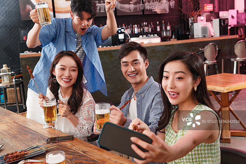 青年朋友边吃饭边拍照图片素材