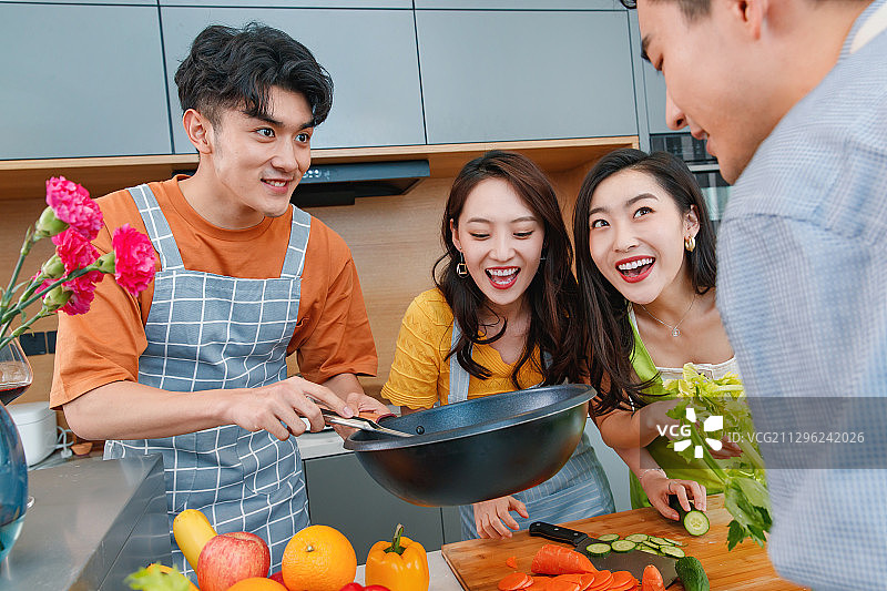 快乐的年轻人在厨房做饭图片素材