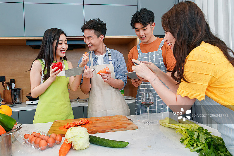 快乐的年轻人在厨房做饭照相图片素材