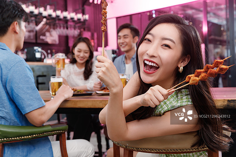 青年女人和朋友一起吃烧烤图片素材