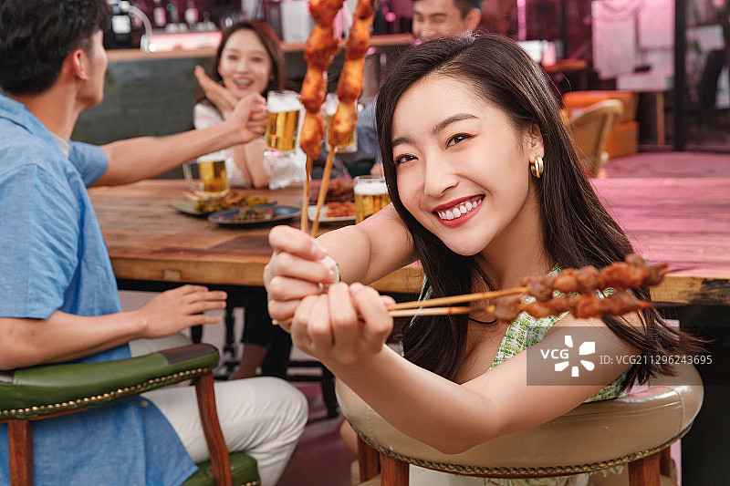 青年女人和朋友一起吃烧烤图片素材