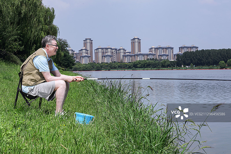 一个老年人在户外湖边钓鱼图片素材
