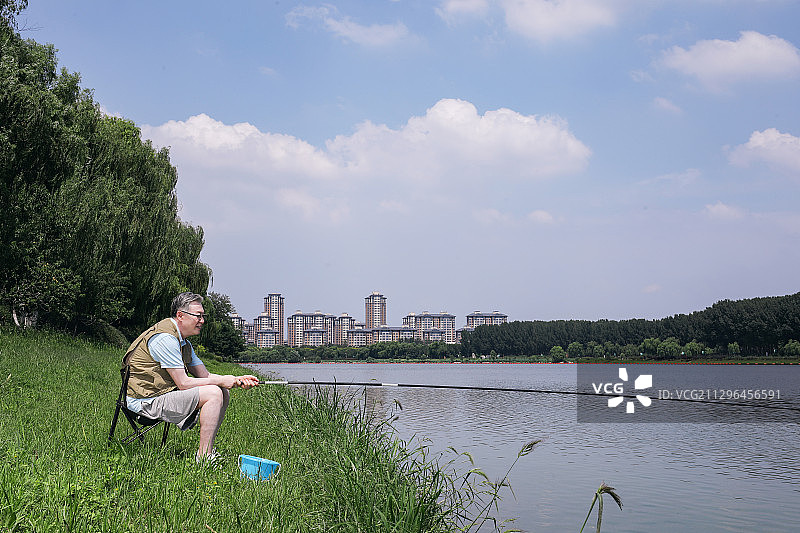 一个老年人在户外湖边钓鱼图片素材