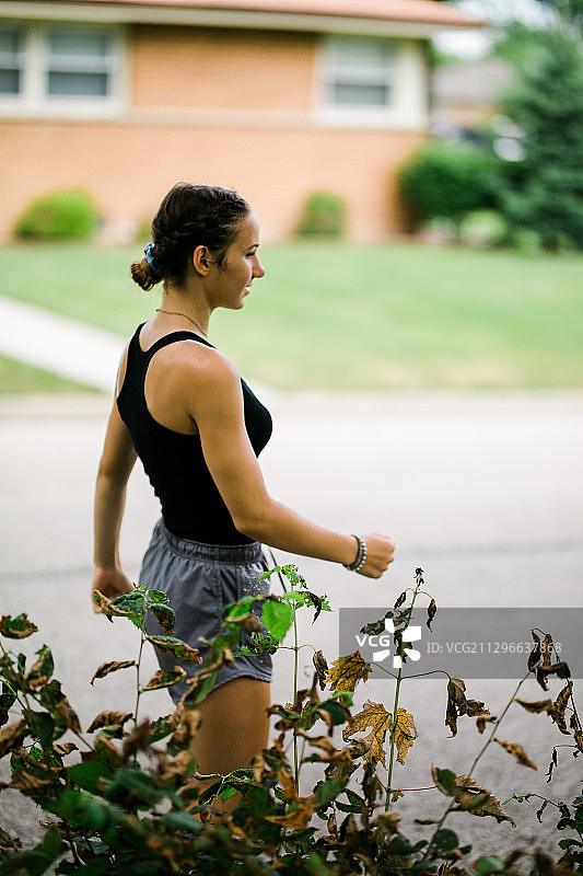 美国阿灵顿高地，慢跑女子返回住宅的侧视图图片素材