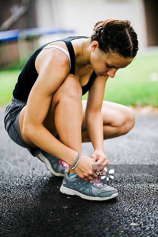 女人在阿灵顿高地道路上系鞋带图片素材