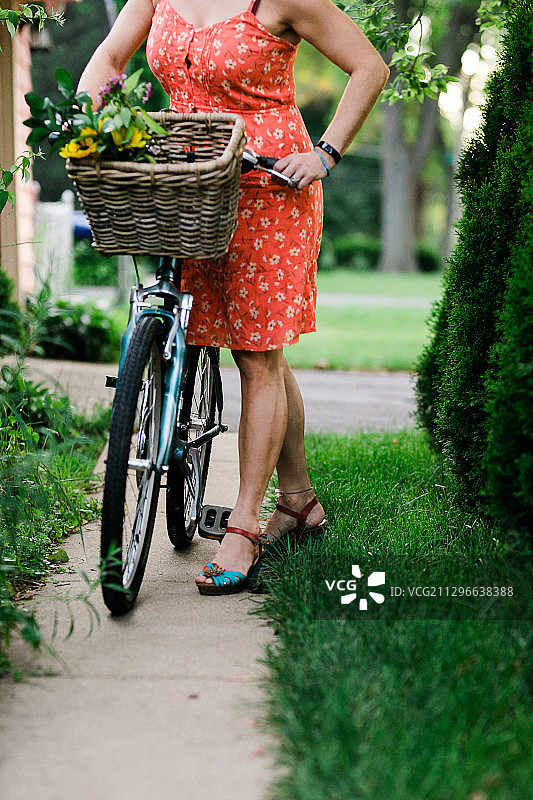 美国阿灵顿高地，带着装满鲜花的自行车篮的女人图片素材