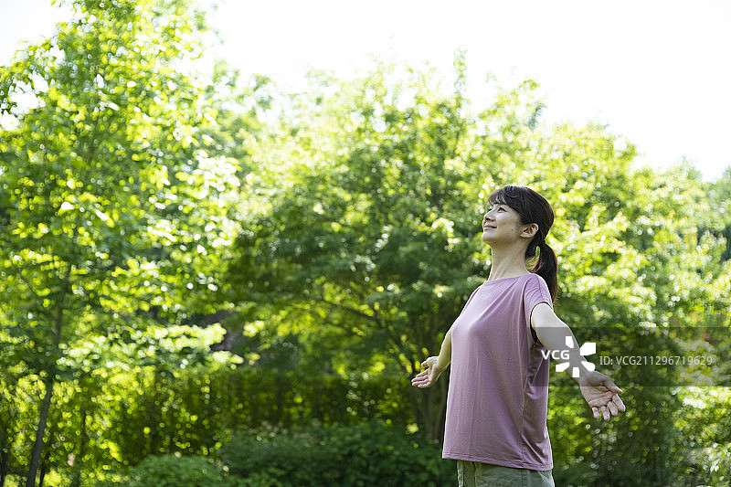 在嫩绿色中深呼吸的女人图片素材