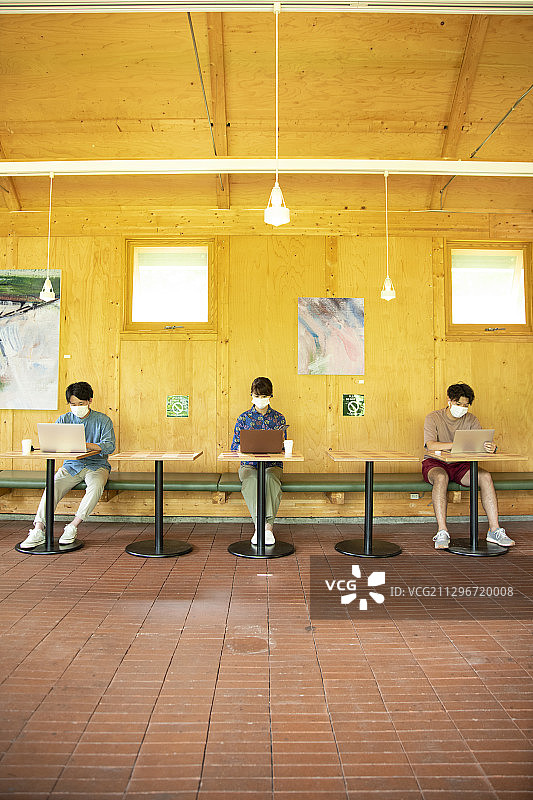 在共享办公室戴口罩工作的男人和女人图片素材