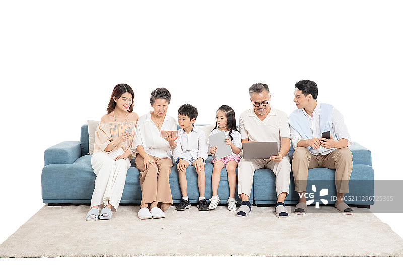一家人坐在沙发上使用电子设备图片素材