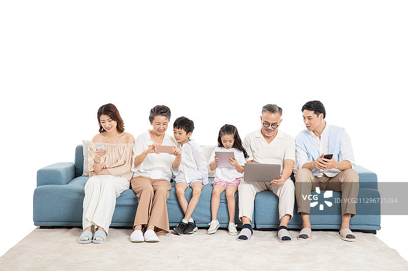 一家人坐在沙发上使用电子设备图片素材