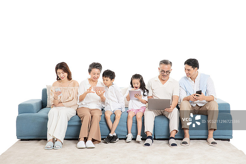 一家人坐在沙发上使用电子设备图片素材