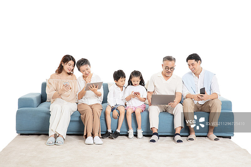 一家人坐在沙发上使用电子设备图片素材