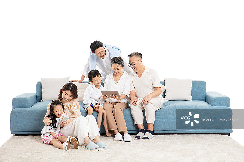在客厅里看平板电脑与玩手机游戏视频的一家六口图片素材
