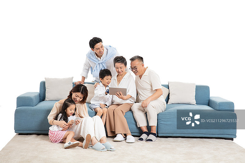 在客厅里看平板电脑与玩手机游戏视频的一家六口图片素材