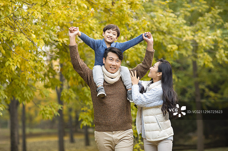 快乐的年轻家庭在树林里共享美好时光图片素材