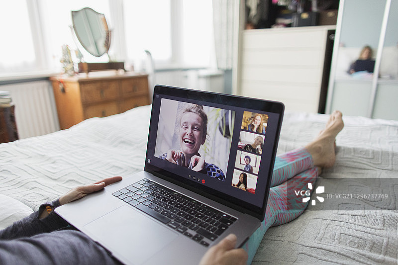 女人在床上用笔记本电脑与朋友视频聊天图片素材