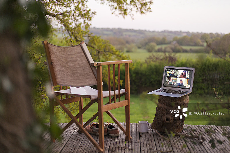同事在乡村阳台用笔记本电脑进行视频聊天图片素材