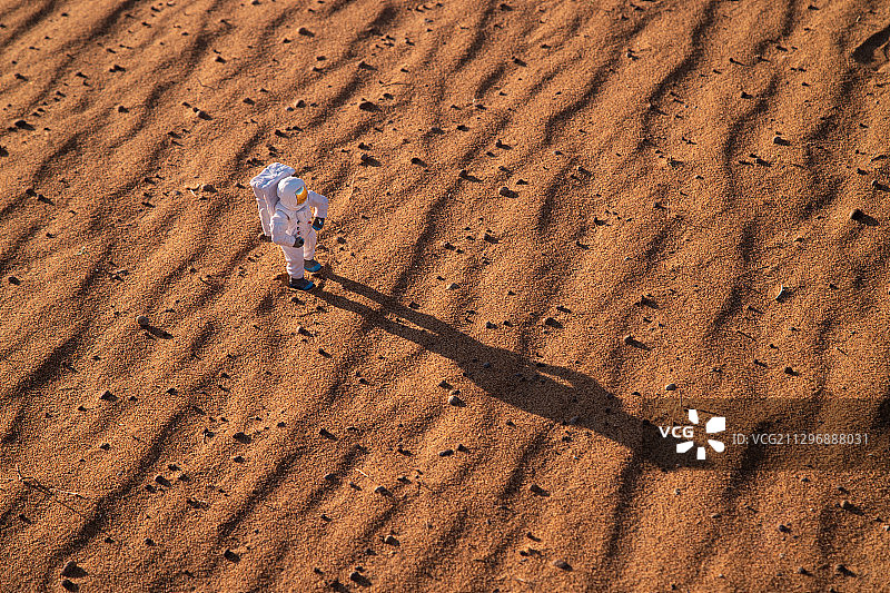 宇航员模型与火星状沙漠地面图片素材
