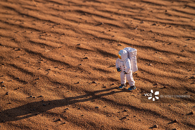 宇航员模型与火星状沙漠地面图片素材