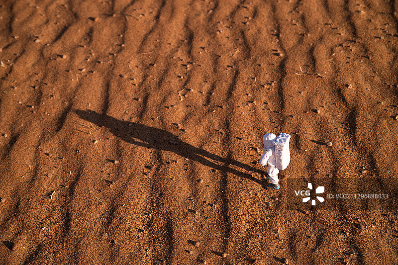宇航员模型与火星状沙漠地面图片素材