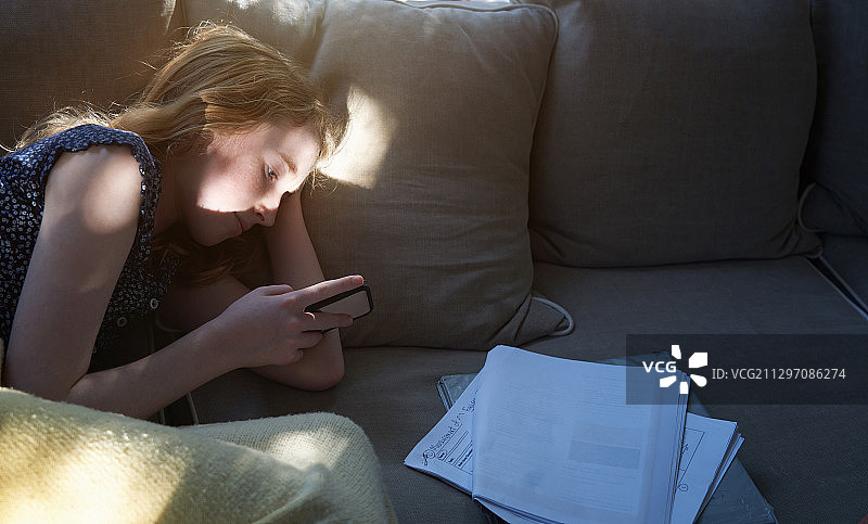 居家女孩使用智能手机进行线上学习图片素材