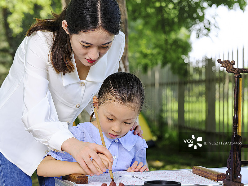 快乐的母女俩在户外写毛笔字图片素材