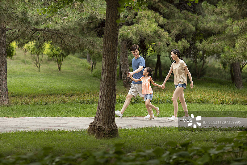 快乐的年轻家庭在公园散步图片素材