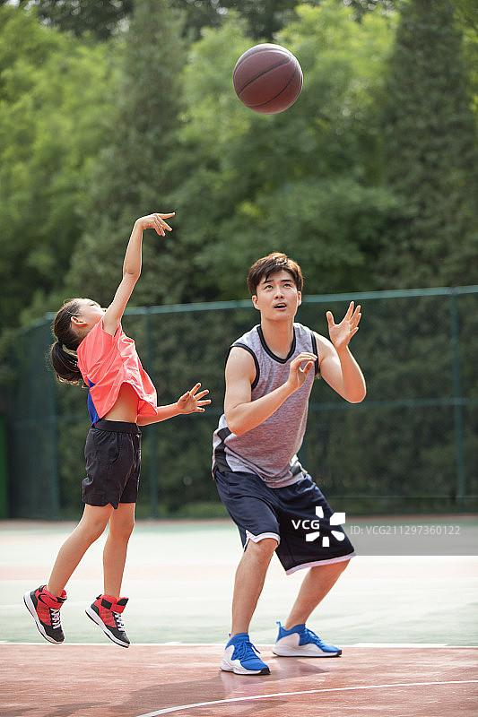 快乐的父女俩在运动场打篮球图片素材