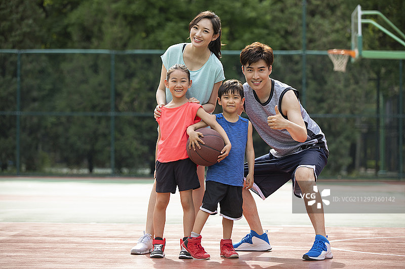 快乐的年轻家庭在篮球场打篮球图片素材