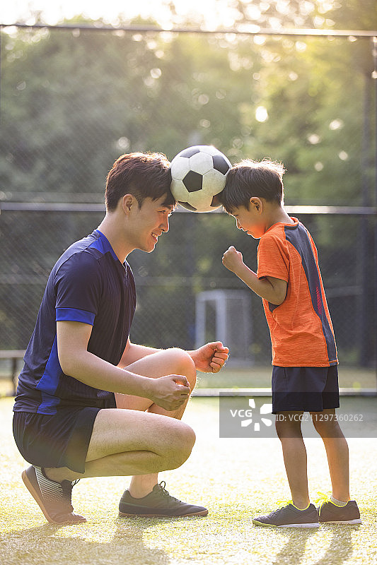 父子俩在足球场玩足球图片素材