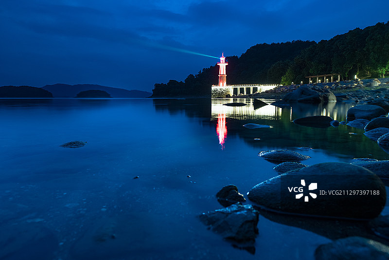夜幕笼罩下，杭州千岛湖羡山半岛的灯塔发射出光芒图片素材