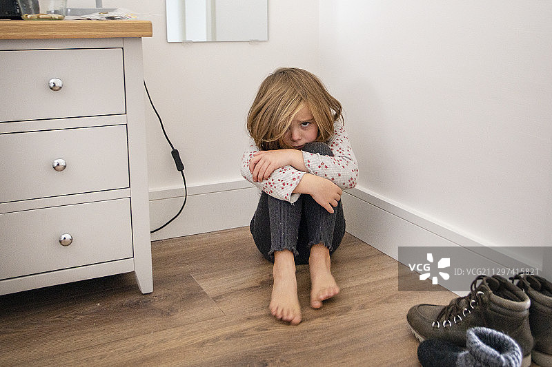 坐在卧室地板上撅嘴的孩子图片素材