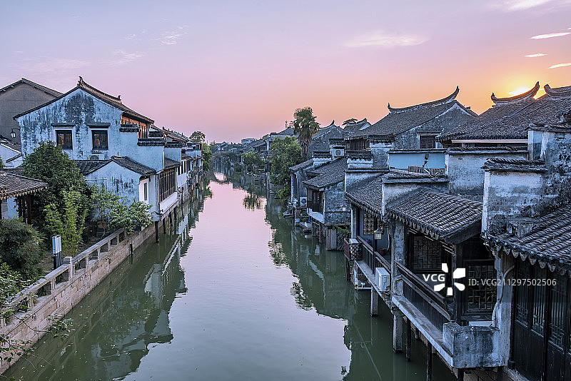 夕阳中的太仓沙溪古镇，河道中倒影出蓝紫色的天空图片素材