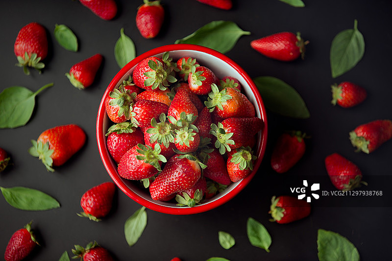 黑色背景下俯拍碗中的草莓和浆果图片素材