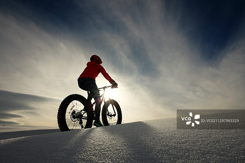 美国斯廷博特斯普林斯雪地上骑自行车的女人图片素材