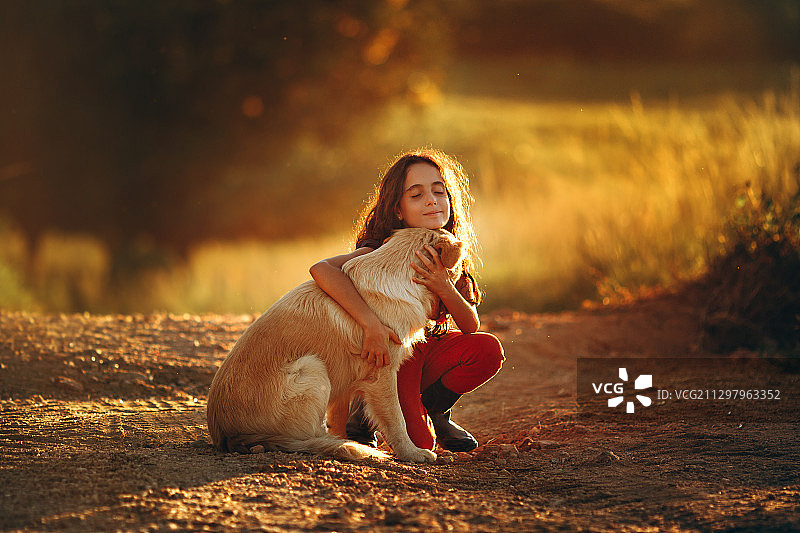 女孩在巴西贝洛奥里藏特田野里拥抱小狗的肖像图片素材