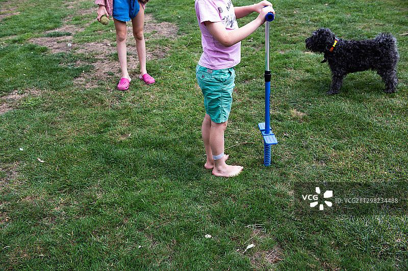 小男孩在草地上玩弹簧单高跷图片素材