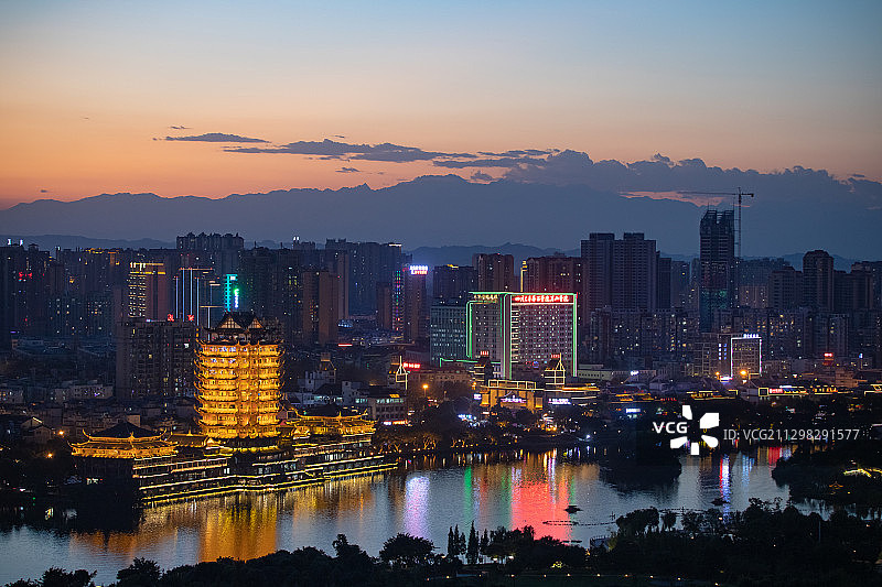 余晖下的眉山城市风景线，在城市中远眺西岭雪山主峰图片素材