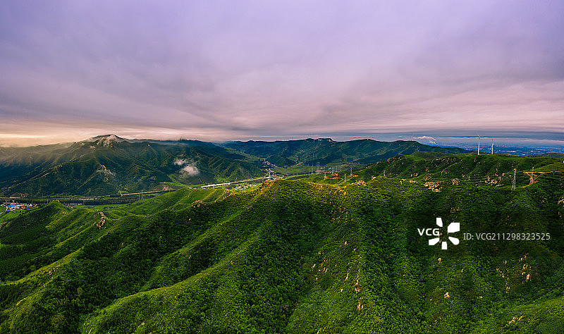晨光照耀山岭，高速公路与电网穿梭其中图片素材