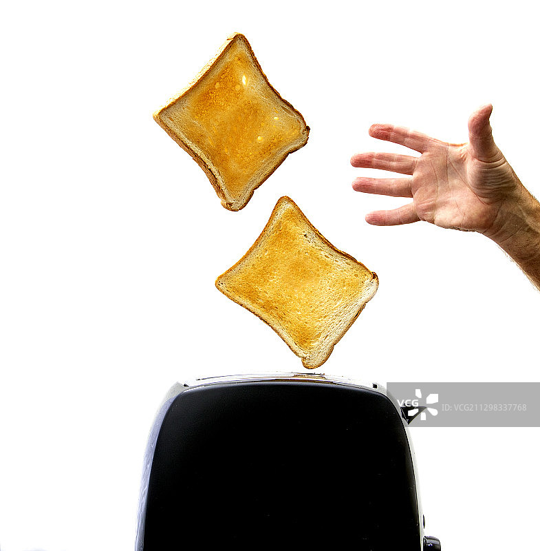 从烤面包机中取出吐司的手图片素材