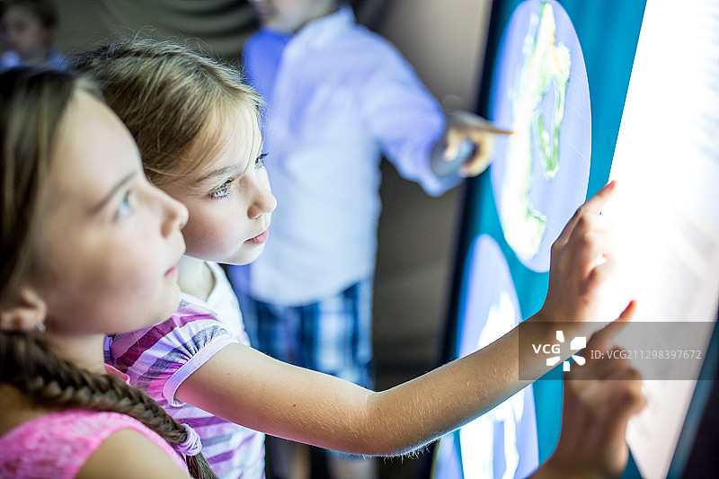 在博物馆触摸屏幕的儿童科学考察之旅图片素材