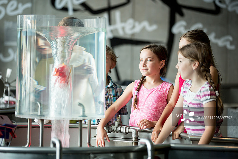 孩子们在科学考察旅行中观察博物馆机器产生的漩涡图片素材