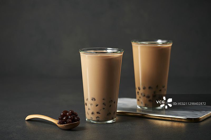 两杯棕色珍珠奶茶和带有珍珠的勺子图片素材