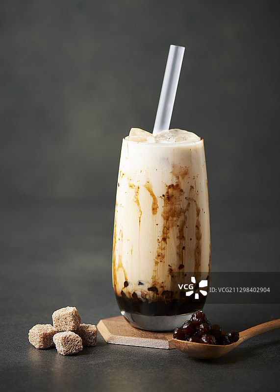 黑糖珍珠奶茶，配吸管、糖和勺子图片素材