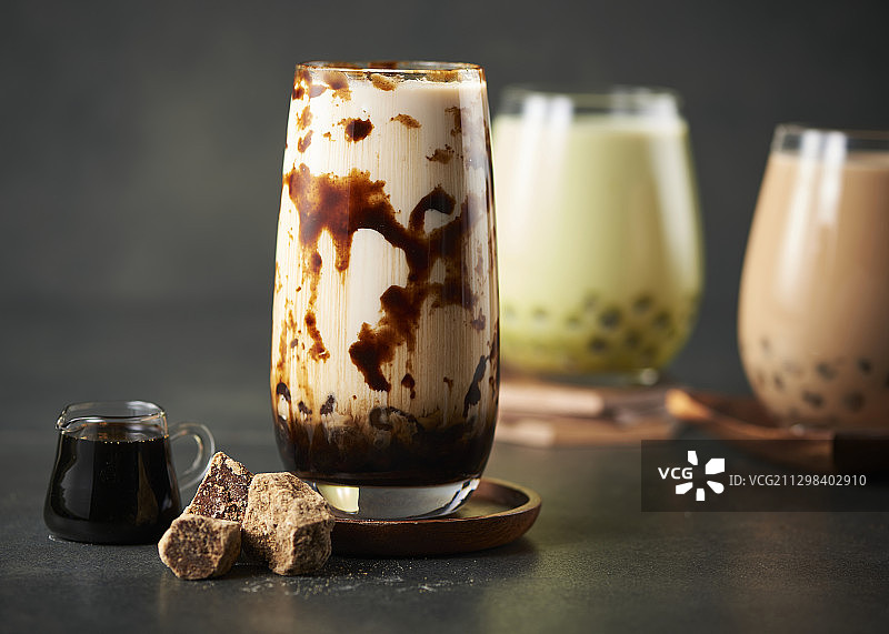 三种珍珠奶茶，旁边是糖和酱汁图片素材