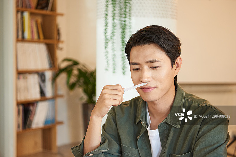 在桌边测试香水的男人图片素材